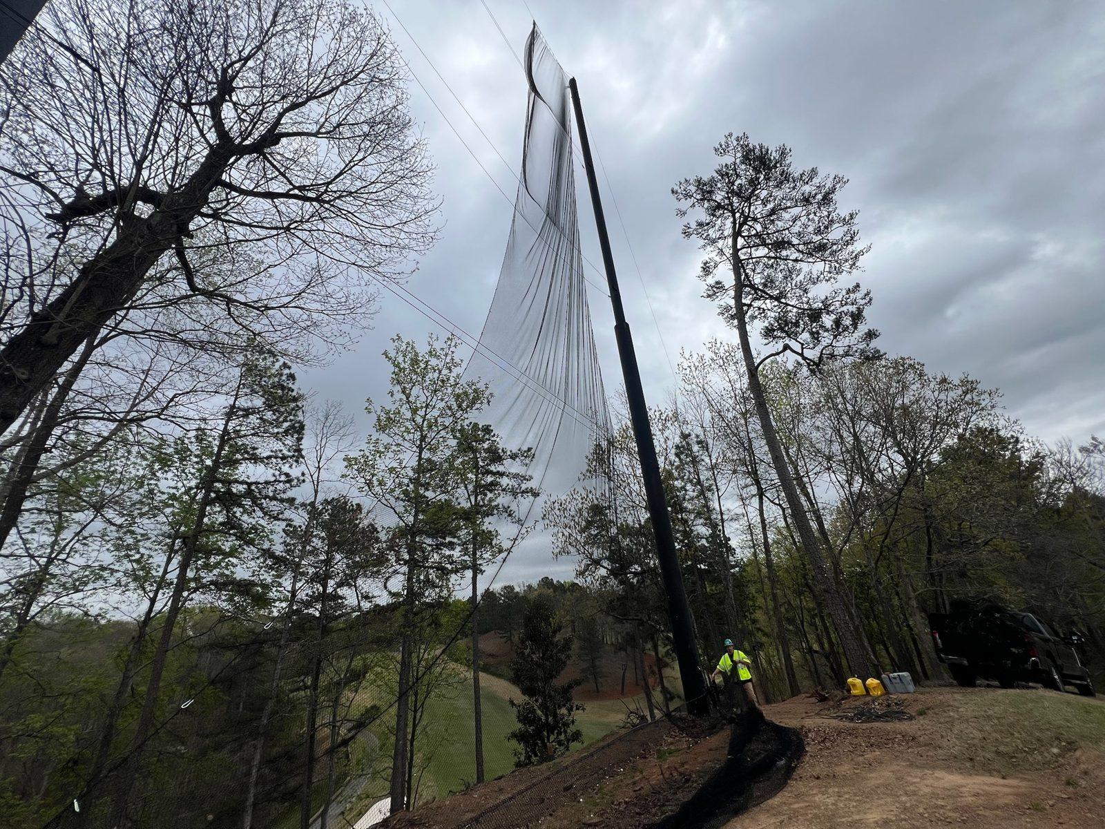 Crew raising a new panel up a pole during Phase 3, Full-height driving range netting enclosure at Dunwoody Country Club in Atlanta