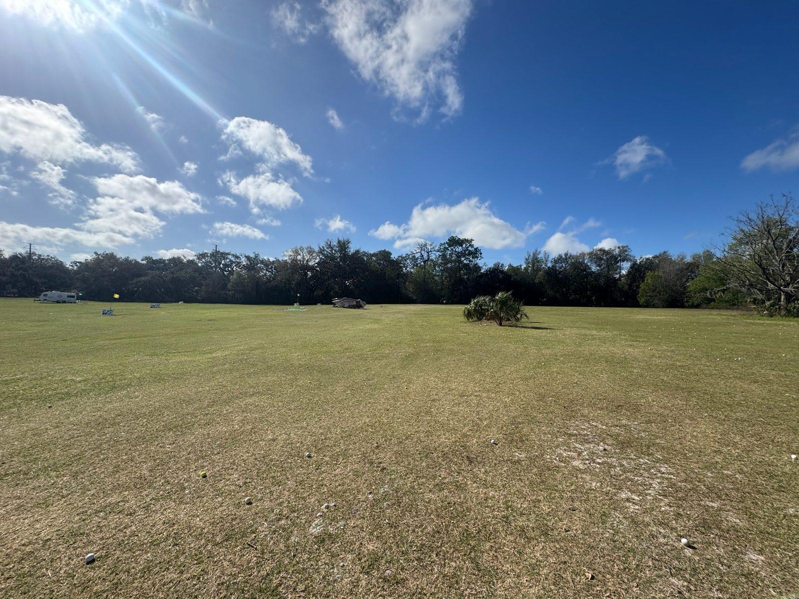 The open range at the March site visit, before any poles or netting, Newly set poles along the cleared boundary at Green Chasers Driving Range