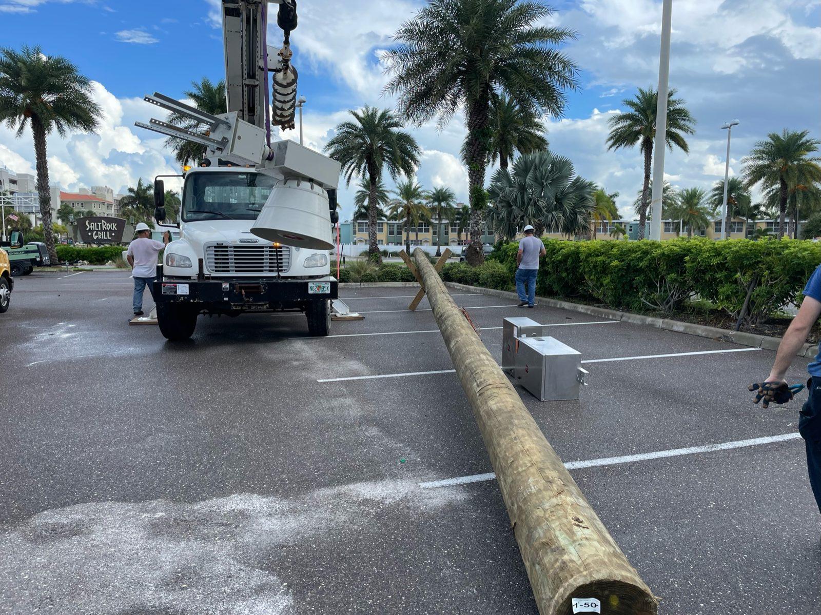 During: New wood pole laid out in the parking lot. Pole Setting at Indian Shores Municipal Center