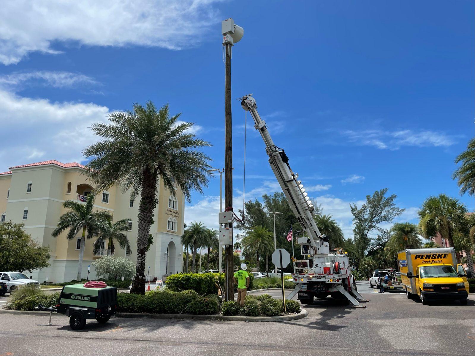 During: Pole lifted at an angle by the digger truck. Pole Setting at Indian Shores Municipal Center