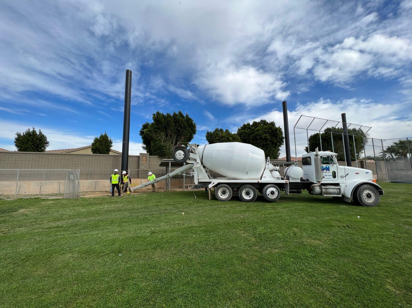 During: Concrete truck pours the pole footings. Baseball Backstop Netting at Millennium High School