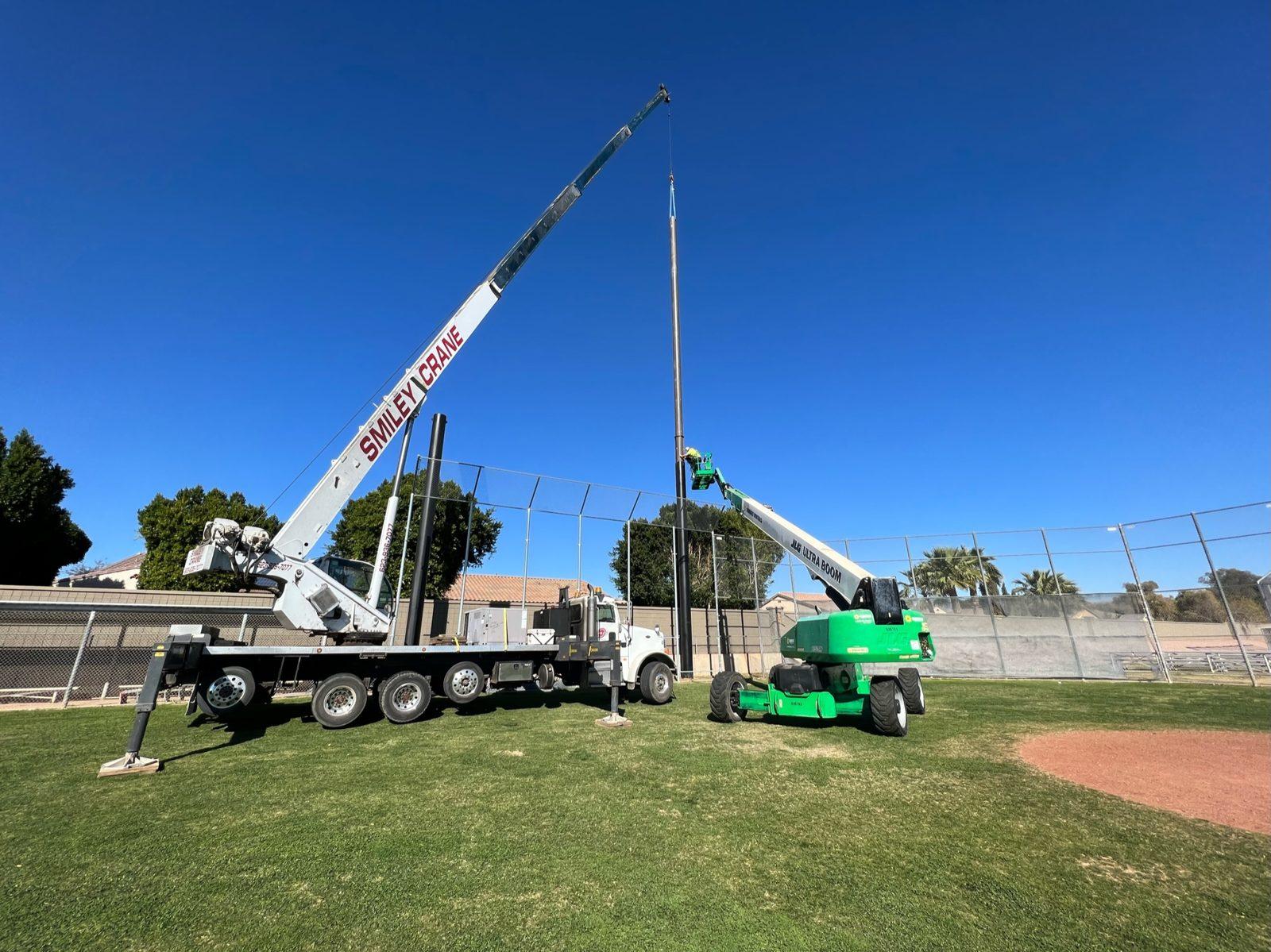 During: Upper section lowered onto a set pole with the lift crew at the joint. Baseball Backstop Netting at Millennium High School