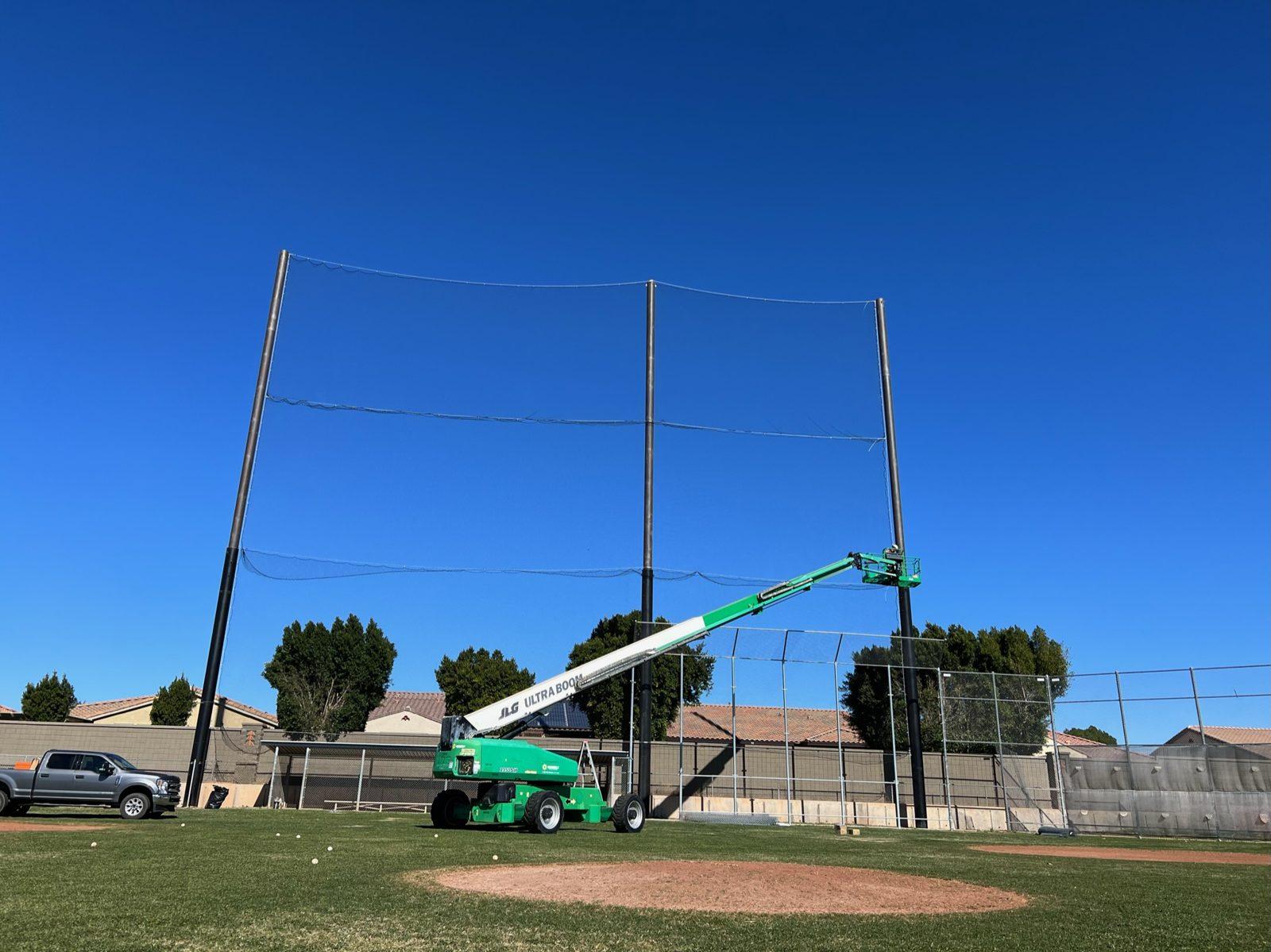 During: Netting hung across both bays as the lift finishes up top. Baseball Backstop Netting at Millennium High School