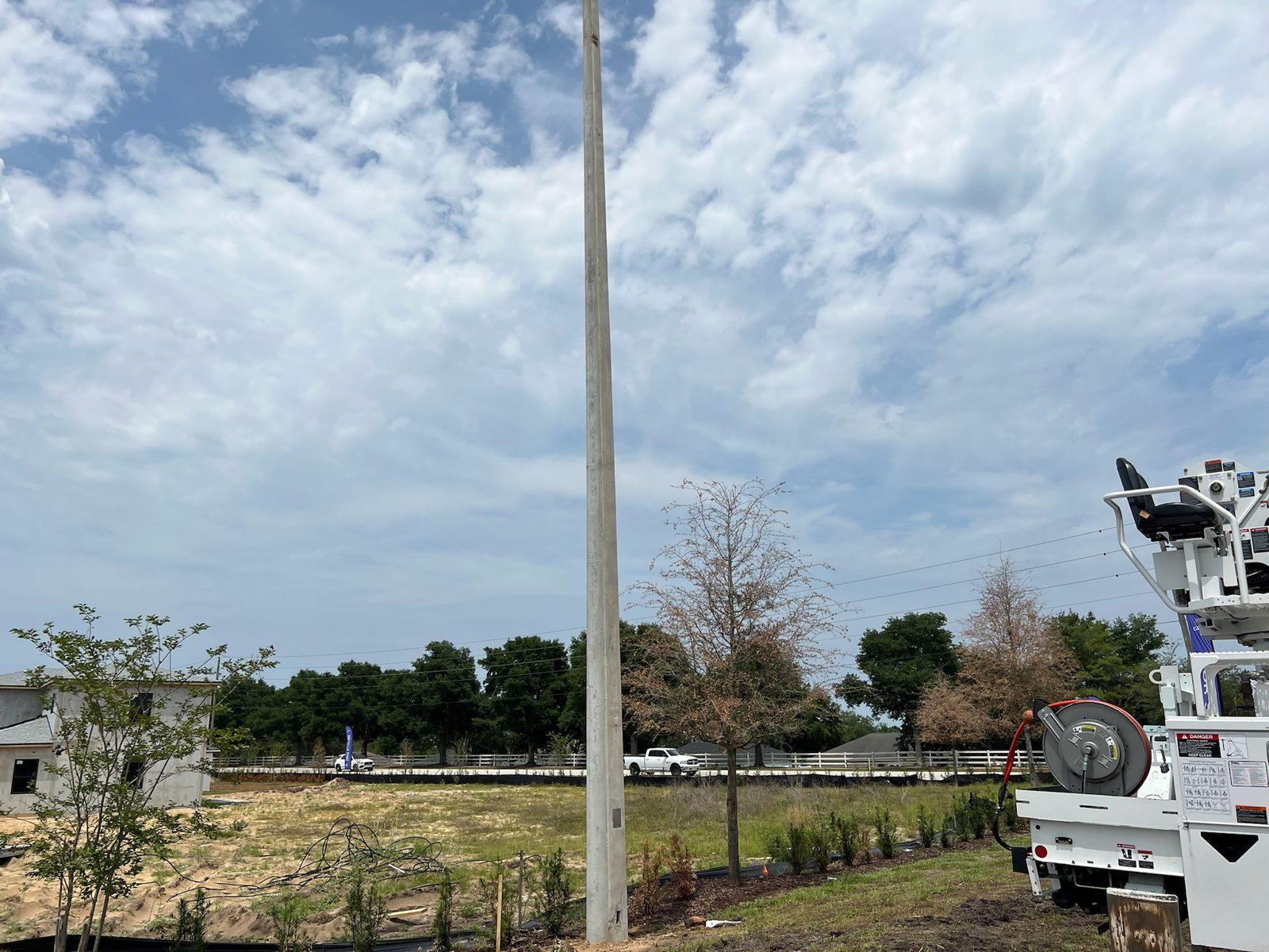 During: Concrete pole standing with the digger truck still alongside. Concrete Pole Setting at an ONX Homes Community