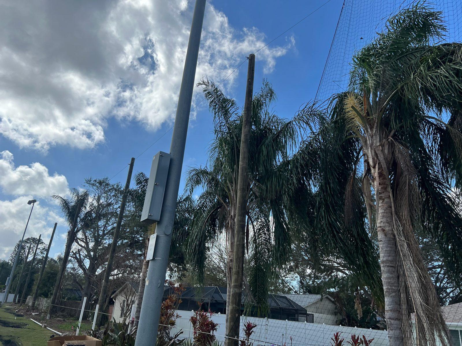 During: Wood pole line rising above the trees along the field. Soccer and Volleyball Netting for Palm Harbor Parks & Recreation