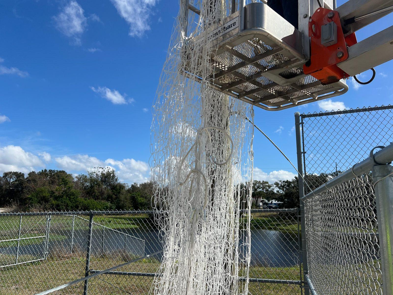 During: White netting raised from the lift along the volleyball court fence. Soccer and Volleyball Netting for Palm Harbor Parks & Recreation