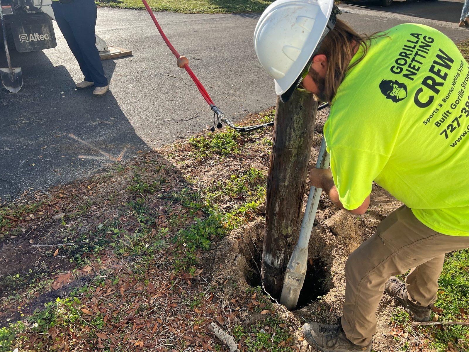 During: Crew works a pole into its hole with a water line. Wood Pole Setting at an RV Park in Central Florida