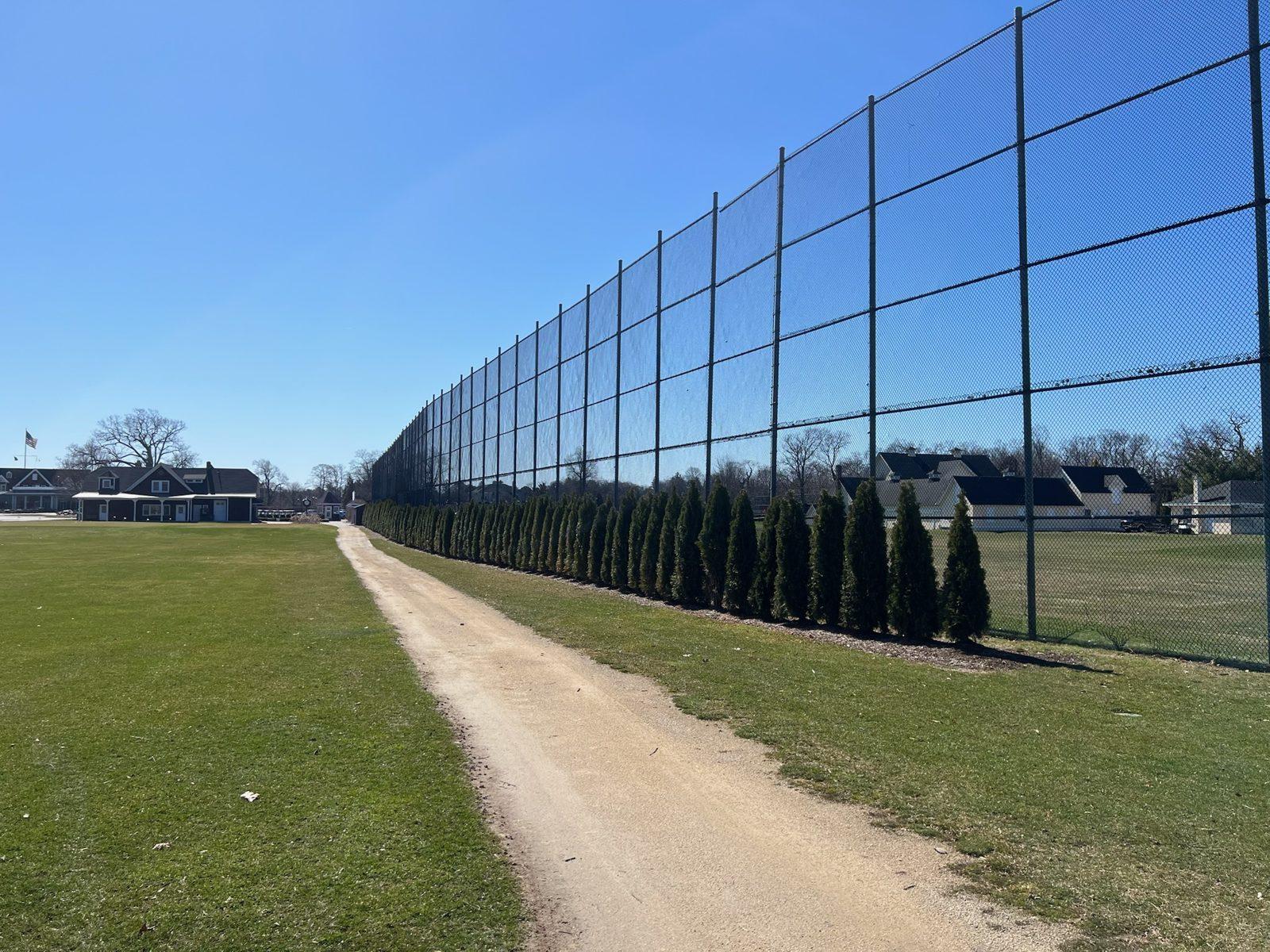 Before: The old steel pole and black netting barrier along the range, March 2026. Driving Range Netting at Southward Ho Country Club