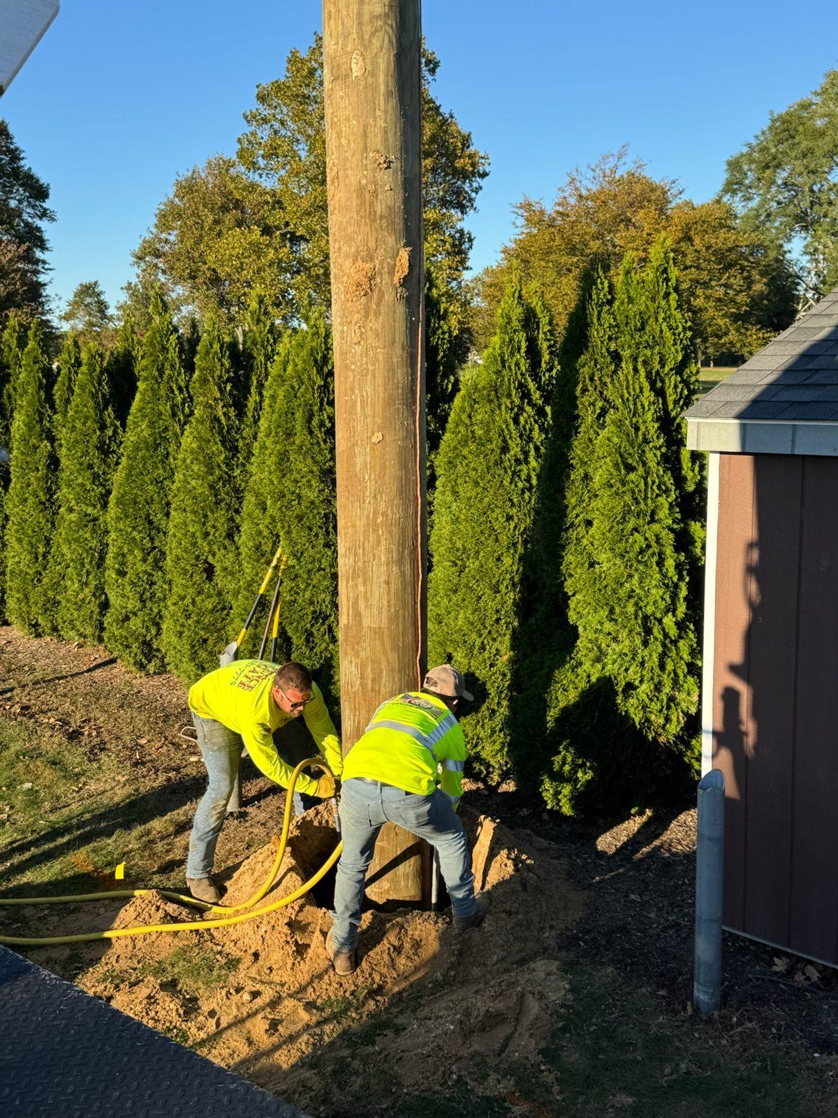 During: Crew setting and plumbing a new wood pole. Driving Range Netting at Southward Ho Country Club
