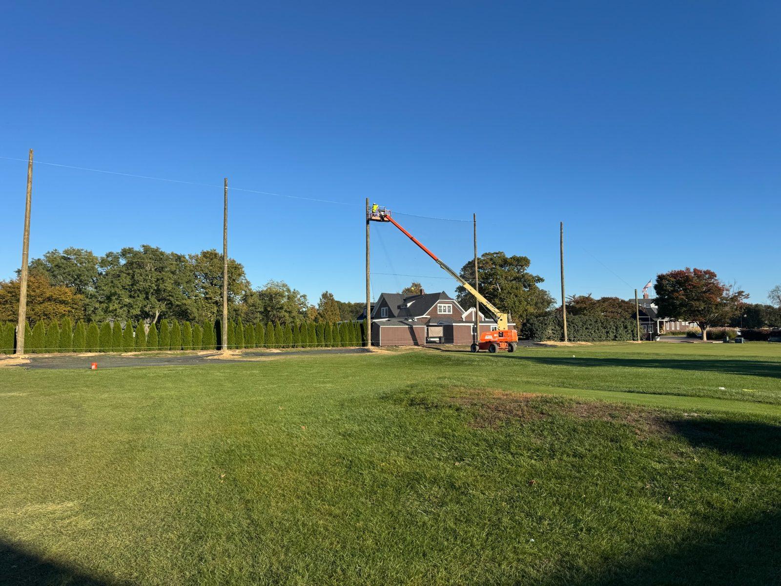 During: Cables strung and the first netting panel going up from a lift. Driving Range Netting at Southward Ho Country Club
