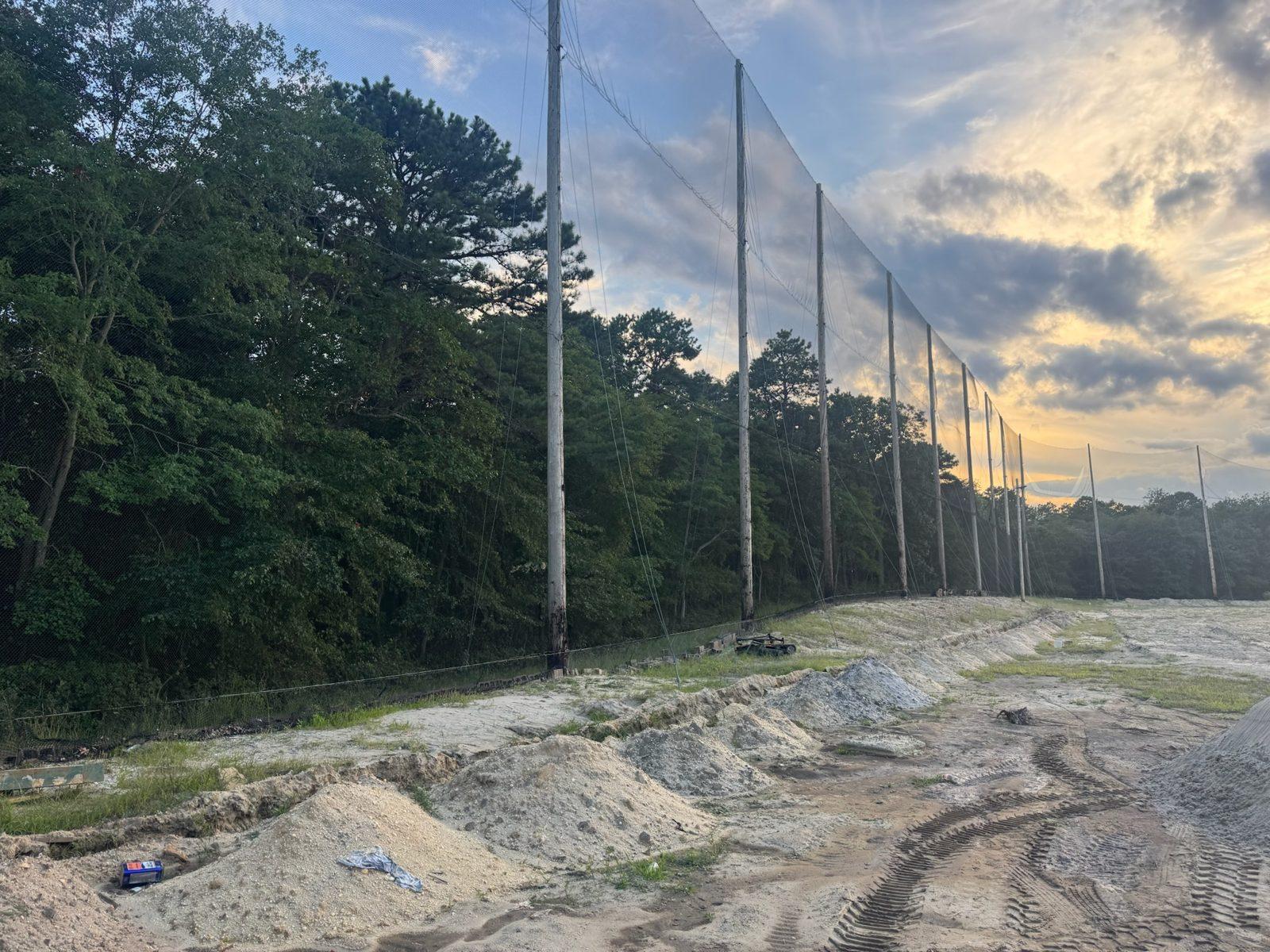Before: Original netting line along the tree line before work began. Driving Range Netting at Toms River Golf Center