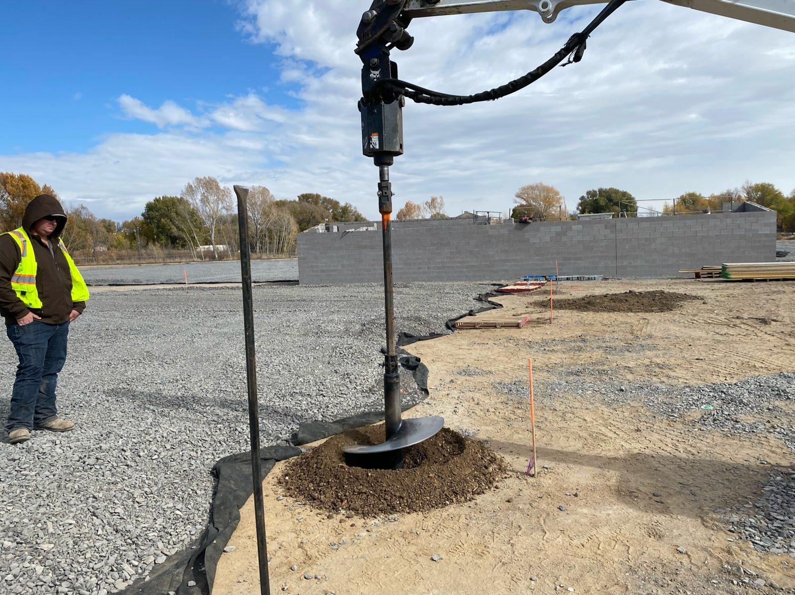 During: Auger drilling the first footing along the pole line. Perimeter Netting at West Las Vegas Middle School