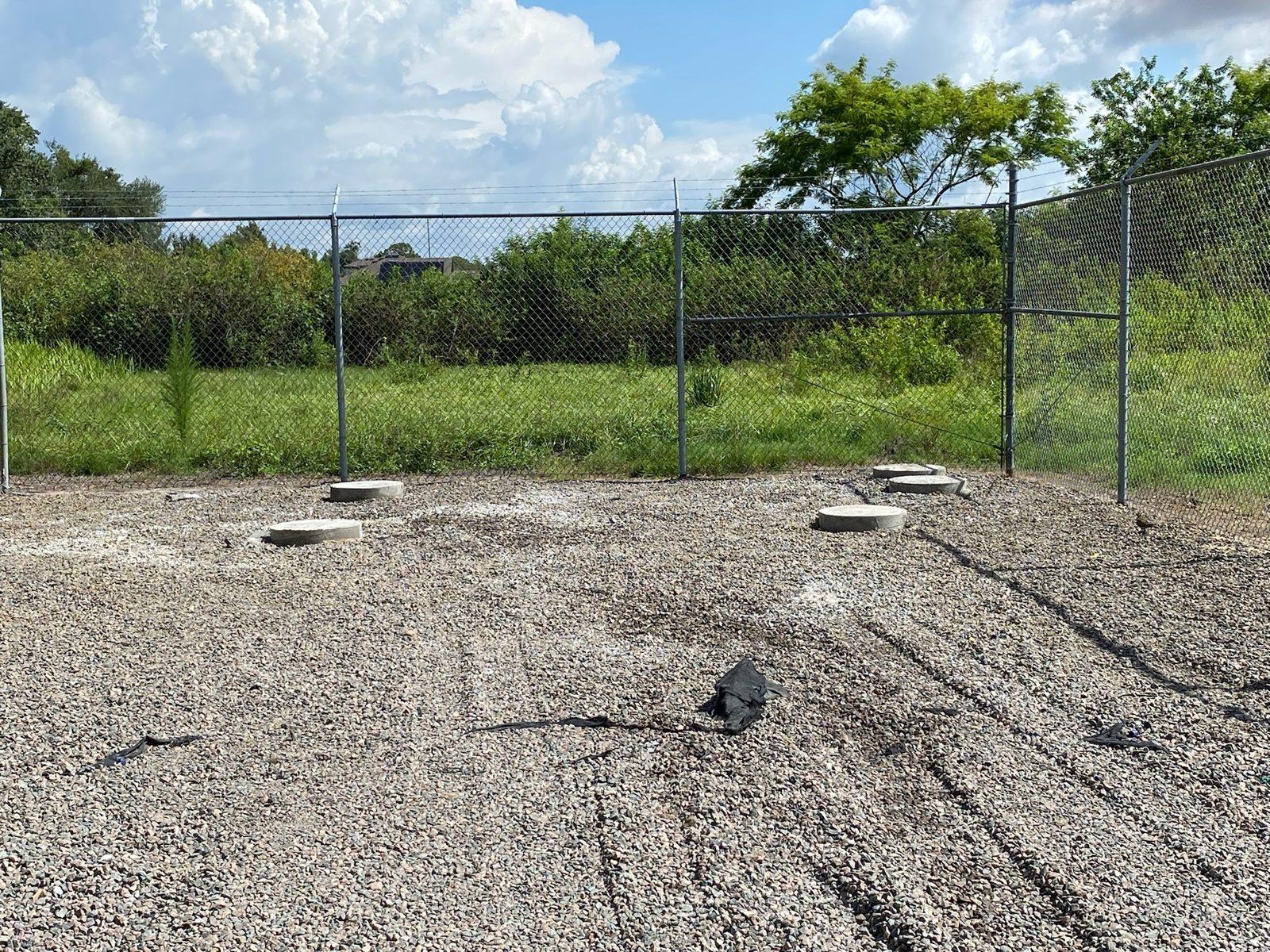 Before: Pink survey flag marking a foundation location in the gravel. Drilled Concrete Foundations at a Telecom Tower Site