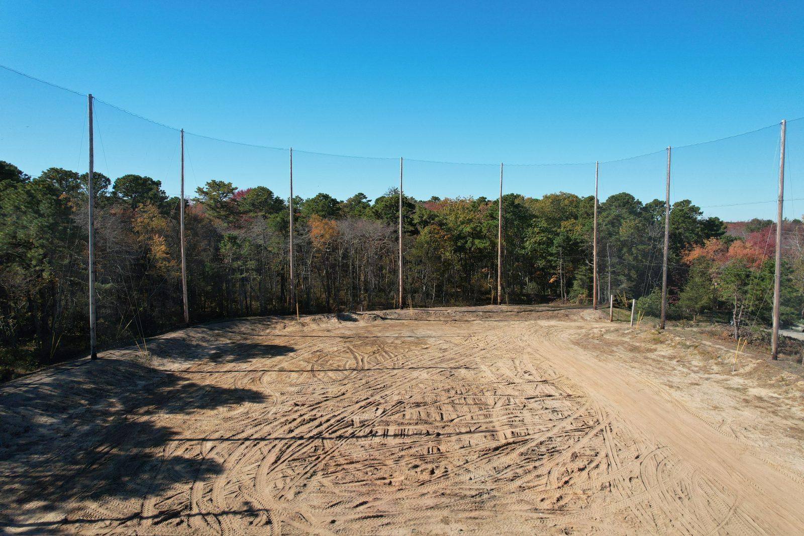 Before: Original netting line along the tree line before work began. Driving Range Netting at Toms River Golf Center